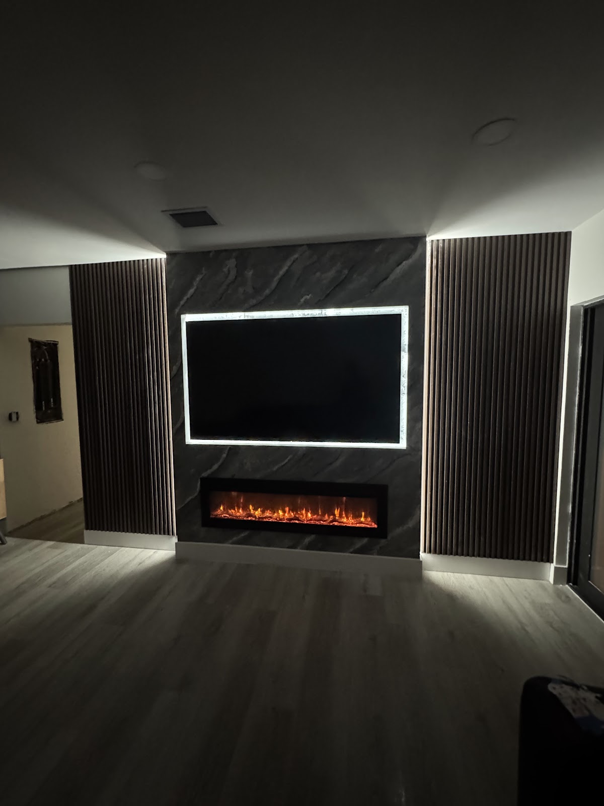 Custom fireplace wall with stone and wood slat panels