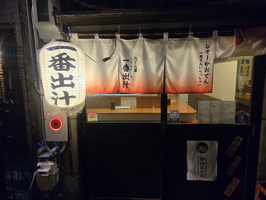 A rain-slicked alley of red lanterns at Aoba Yokocho, Shizuoka's oden street, at dusk