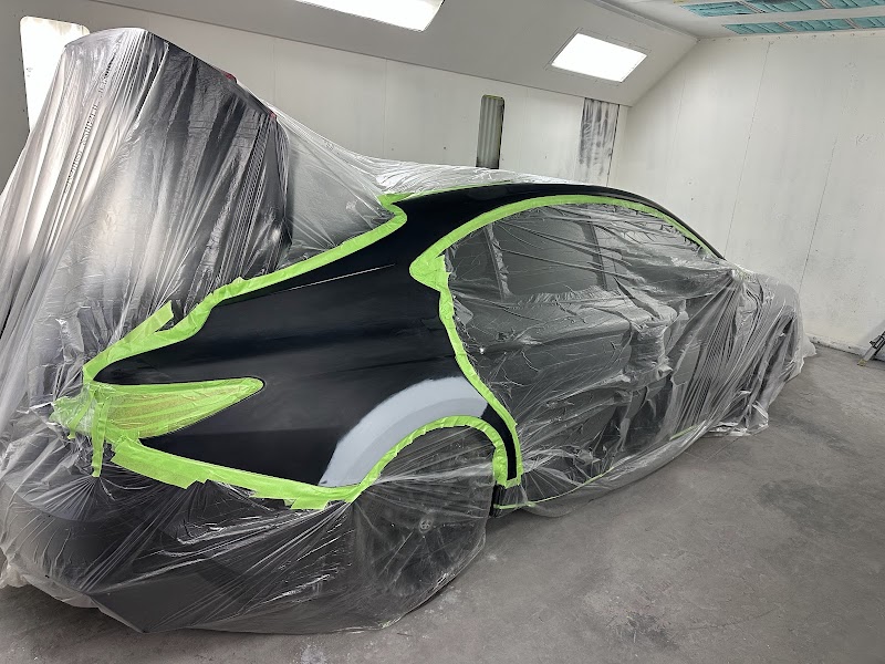 Vehicle receiving final detailing touches after a complete body repair.