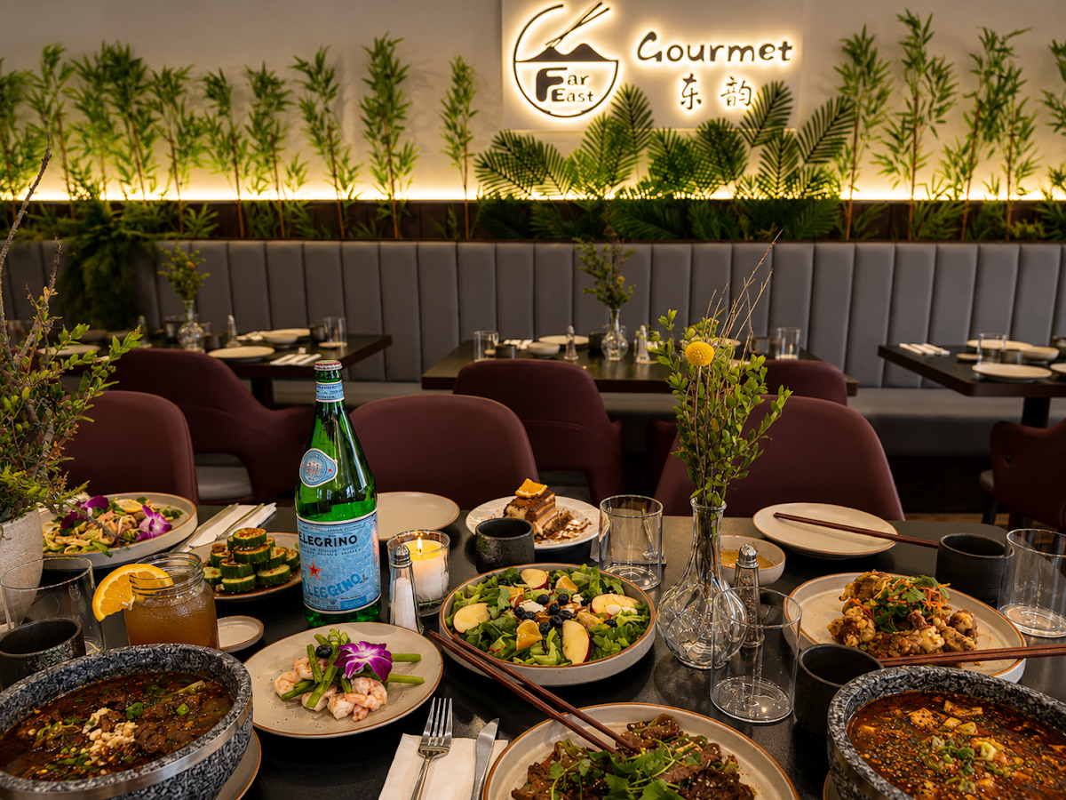 Far East Gourmet restaurant interior with a table laden with various Asian dishes and drinks.