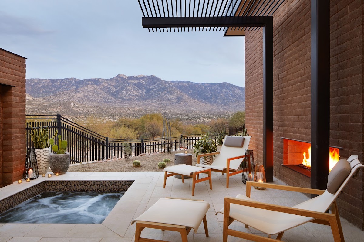 Private terrace with hot tub, lounge chairs, fireplace, and mountain views at Miraval Arizona Resort & Spa.