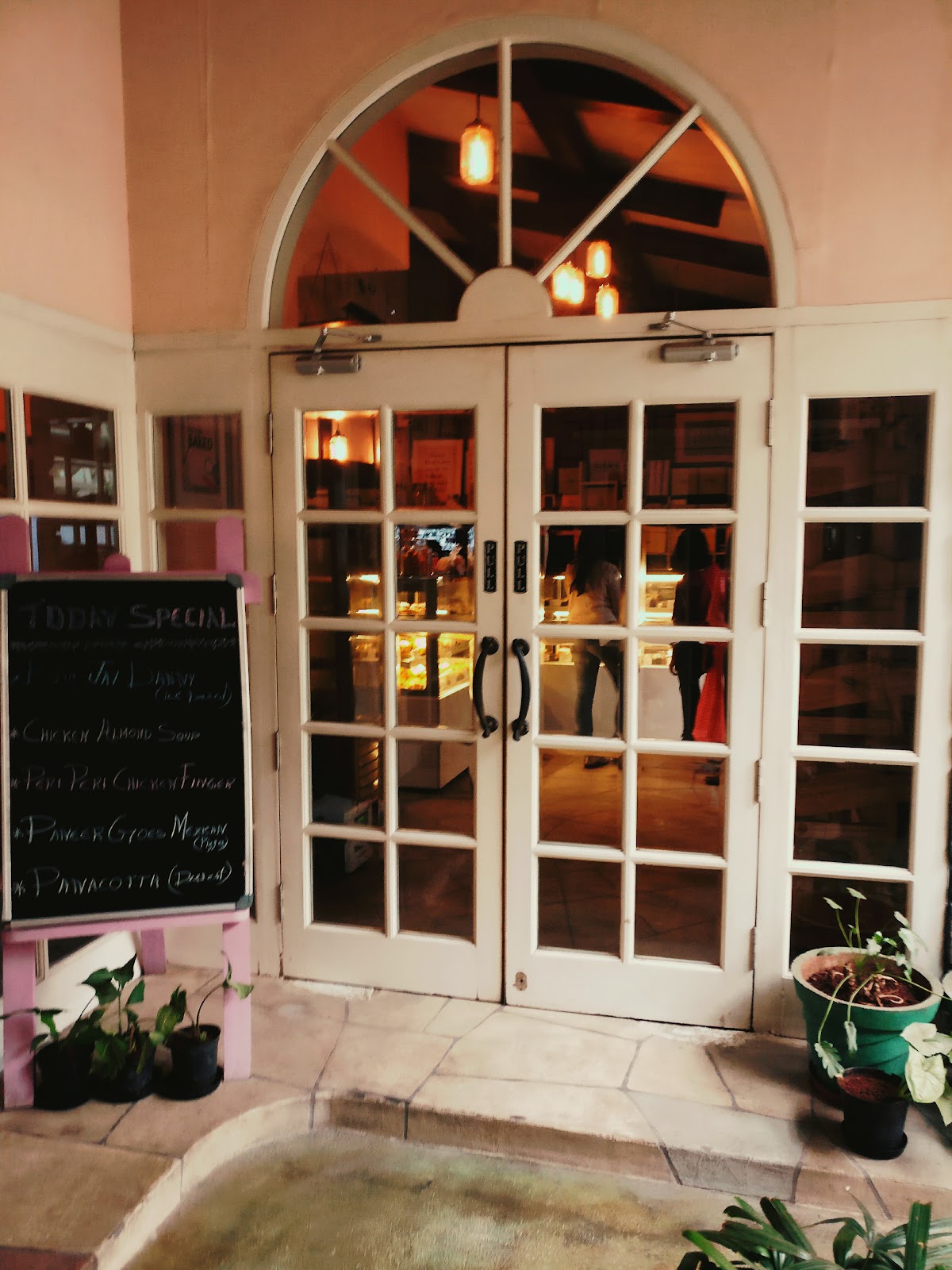 The charming entrance of Glen's Bakehouse invites with warm lighting and a rustic feel.