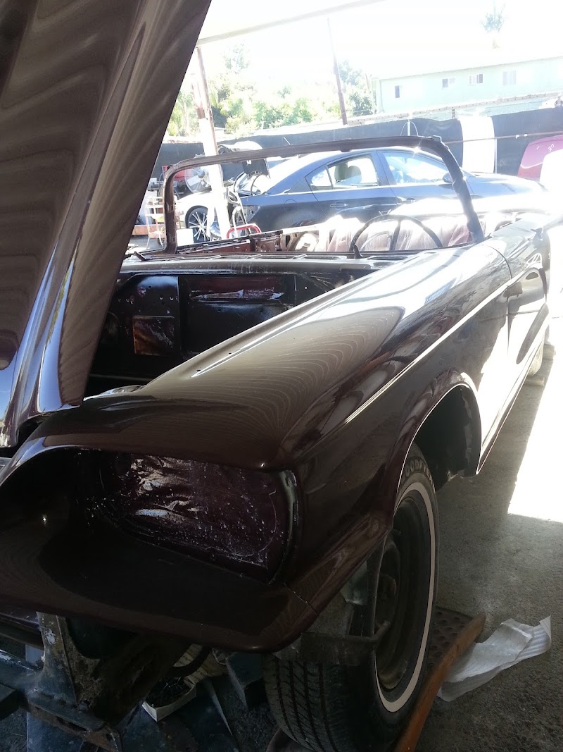 Technician carefully assessing front-end damage from a recent collision