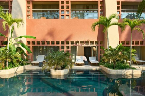 Palm trees line a manicured lawn beside a sandy beach and sparkling ocean at The Westin Playa Vallarta.