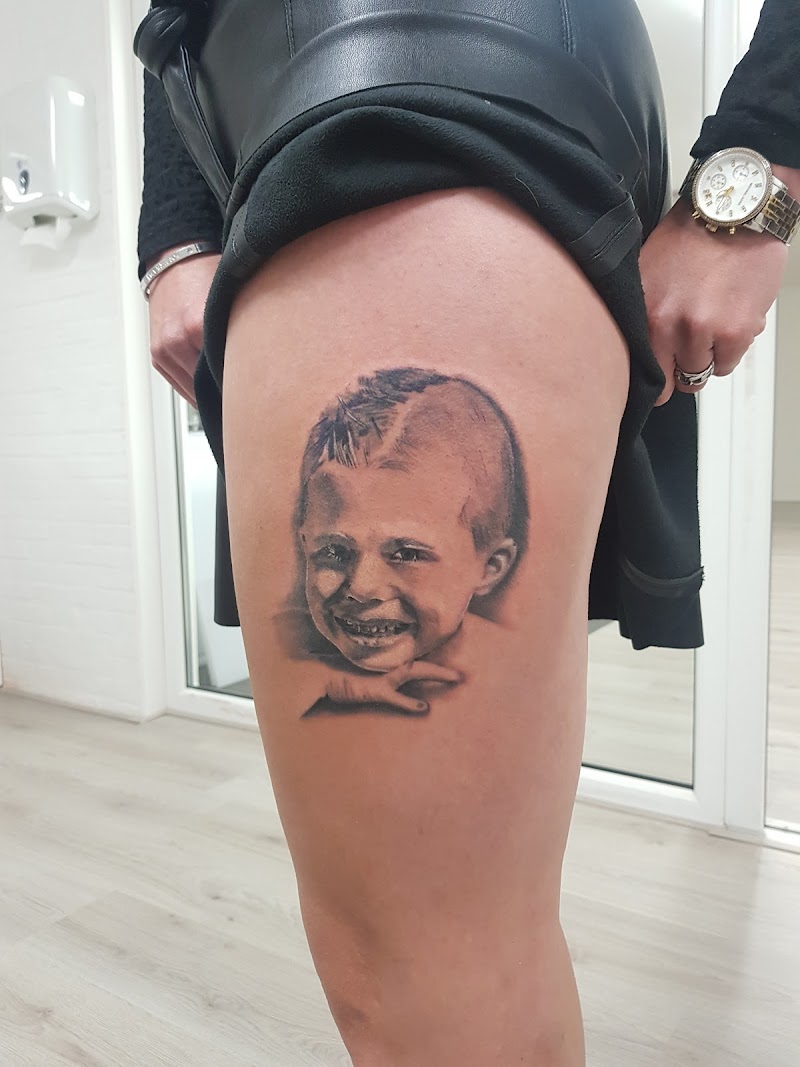 Realistisch portret van een lachend jongetje op het bovenbeen.