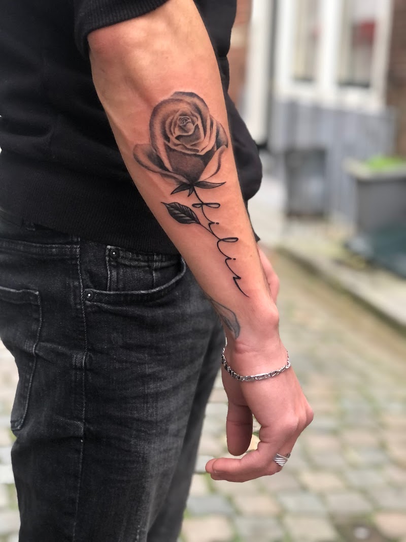 Realistische roos met de naam 'Lilian' in sierletters op de onderarm.