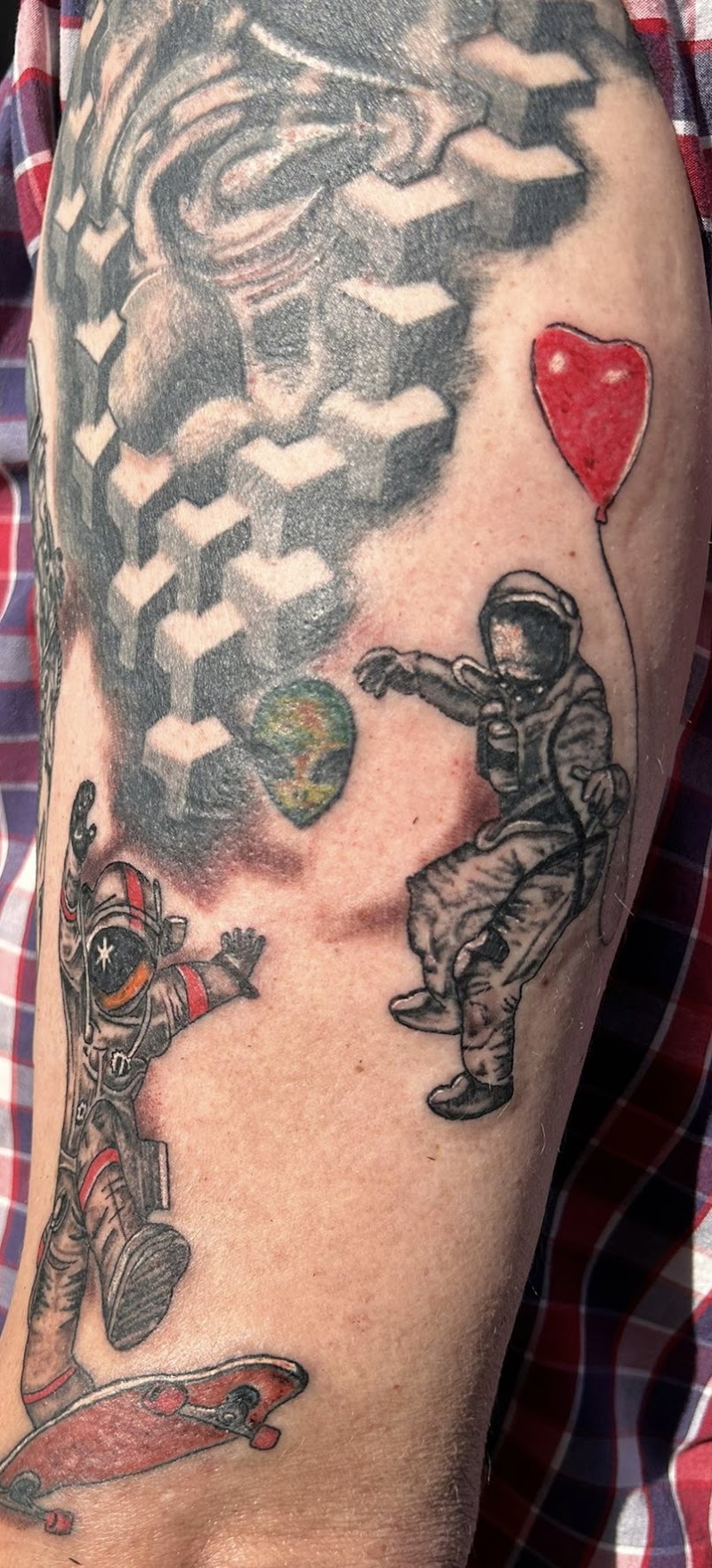 Twee astronauten, één op skateboard, één met ballon, en een alienhoofd.