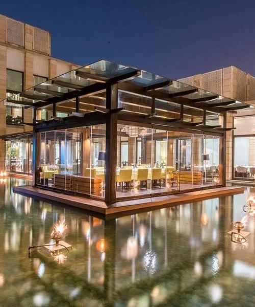 Indian Accent's elegant exterior with shimmering water reflections highlighting its modern architectural charm.