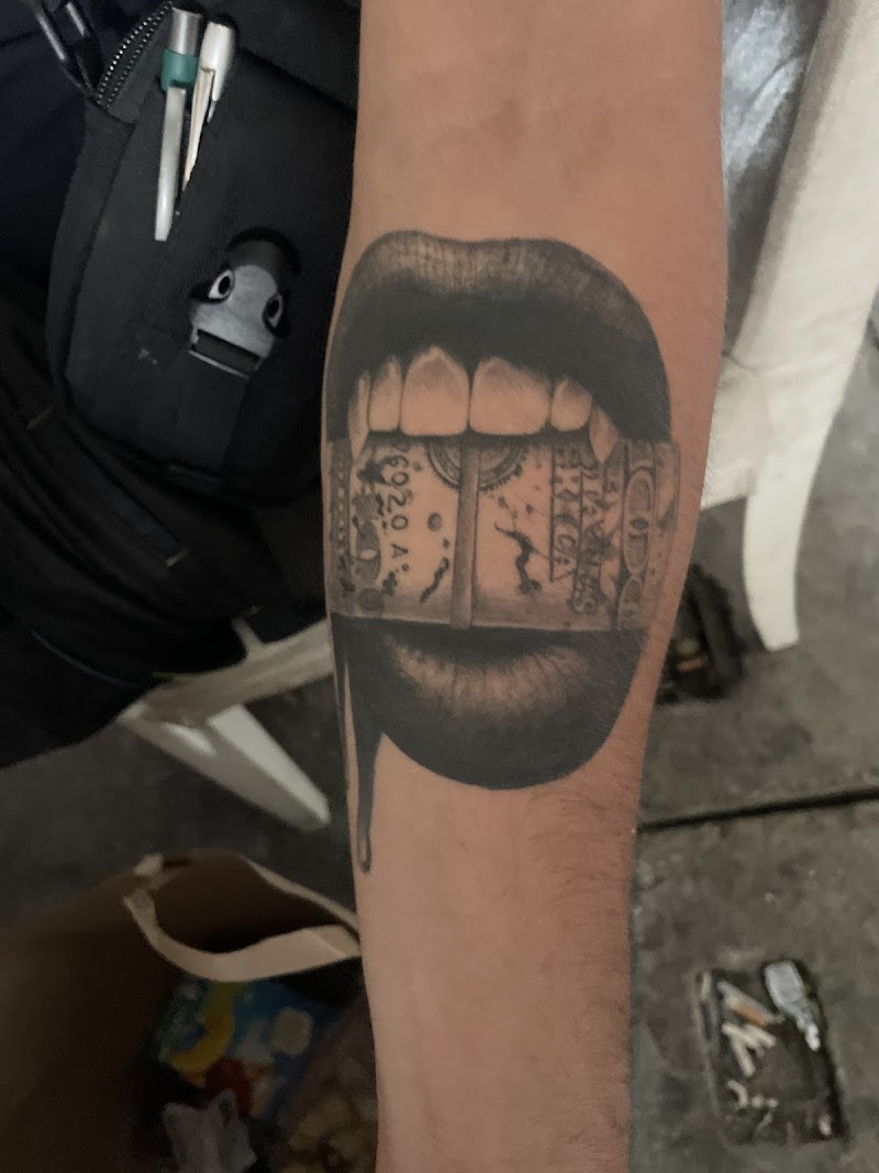 Realistische tattoo van lippen die op een rolletje geld bijten.