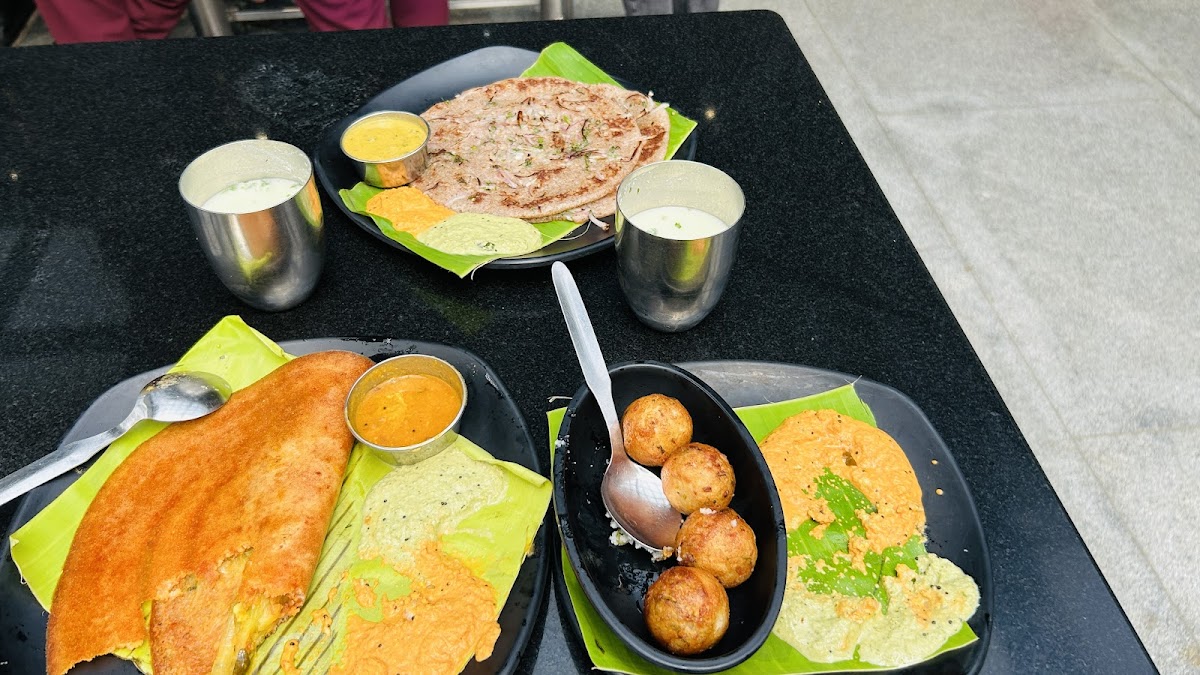 A colorful spread of South Indian delights at The Rameshwaram Cafe - Indiranagar, showcasing traditional dosas and chutneys.