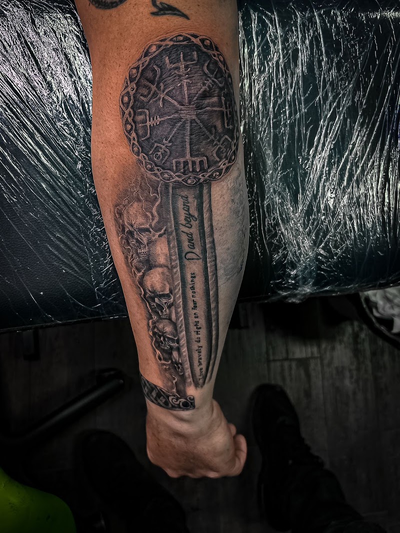 Zwart-wit tattoo van een Vegvisir kompas, zwaard met tekst en schedels.
