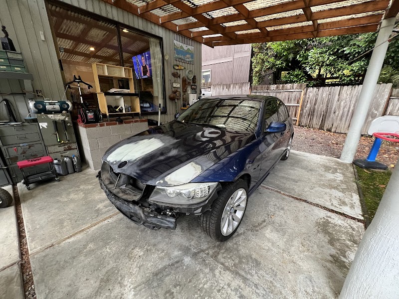 Technician performing final inspection on completed collision repair work.