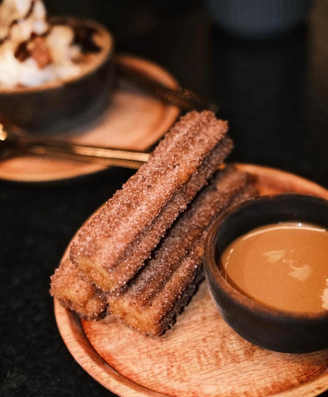 Comal's decadent churros with a rich chocolate dipping sauce, capturing the essence of authentic Mexican indulgence.