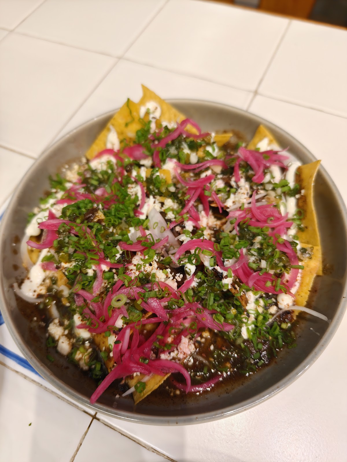 Comal's vibrant enchiladas topped with fresh herbs and pickled onions, capturing the essence of its flavorful Mexican cuisine.