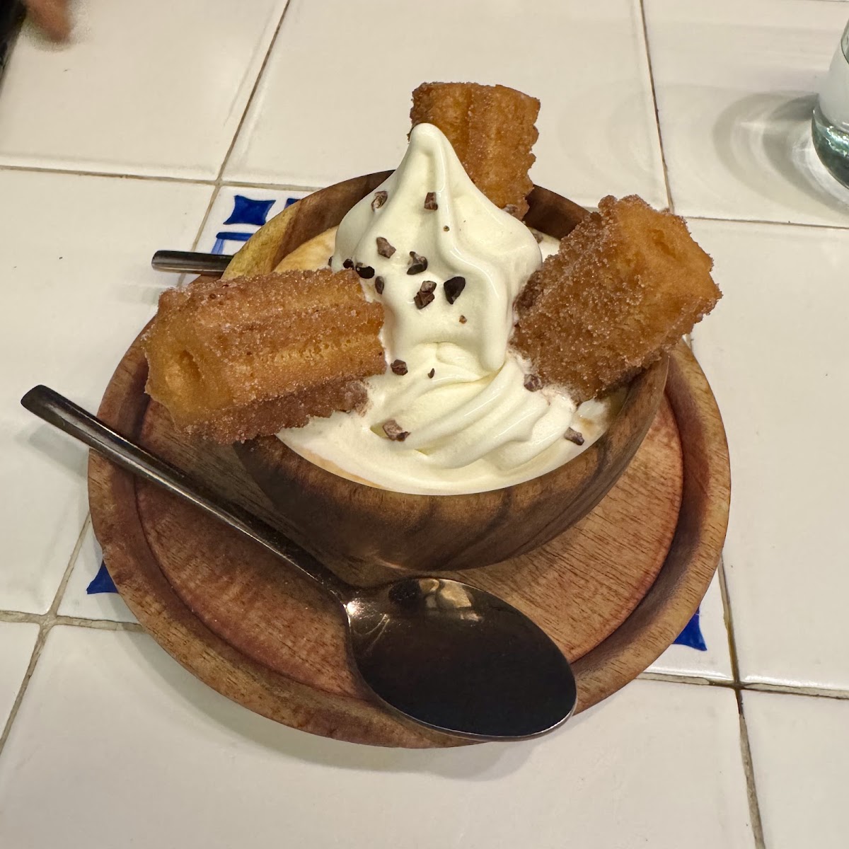 Comal's delightful dessert featuring creamy soft serve adorned with crunchy churros, a sweet treat that captures the essence of Indulgence.