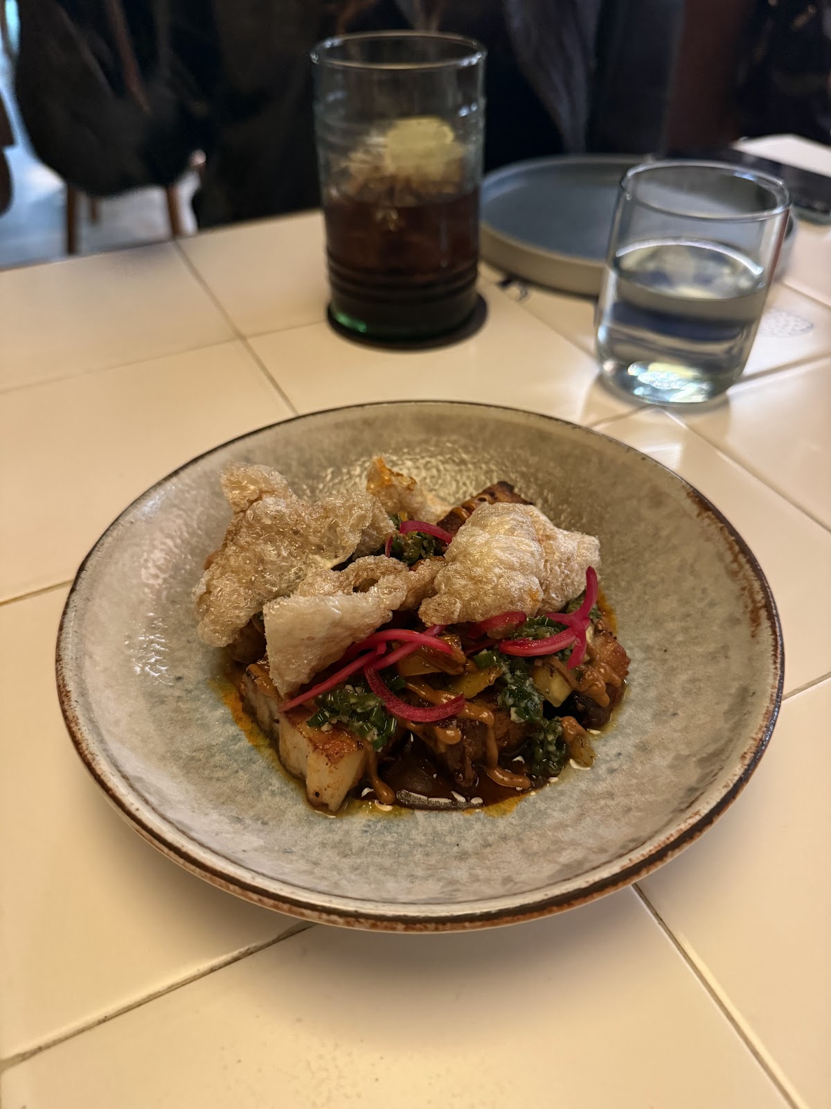 Comal's vibrant dish featuring crispy chicharrones and pickled onions, reflecting the restaurant's colorful and bold culinary style.