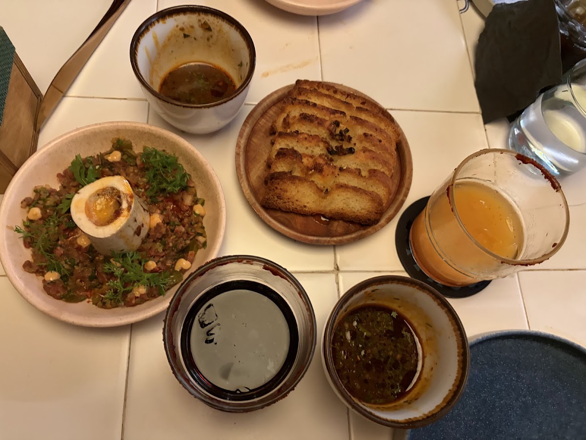 Comal's vibrant spread featuring bone marrow with toasted bread, paired with a colorful dipping sauce, showcasing the restaurant's flavorful and creative culinary approach.
